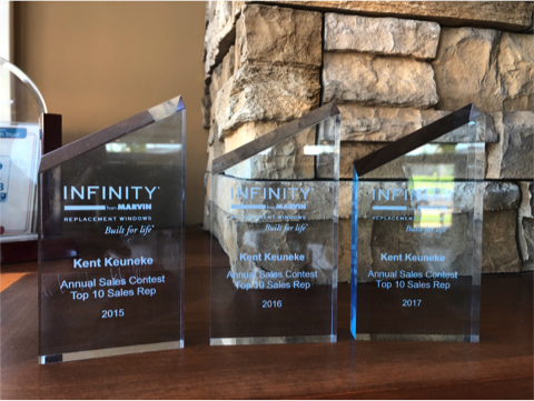 Photo of multiple Infinity awards received by a Bushey's staff member